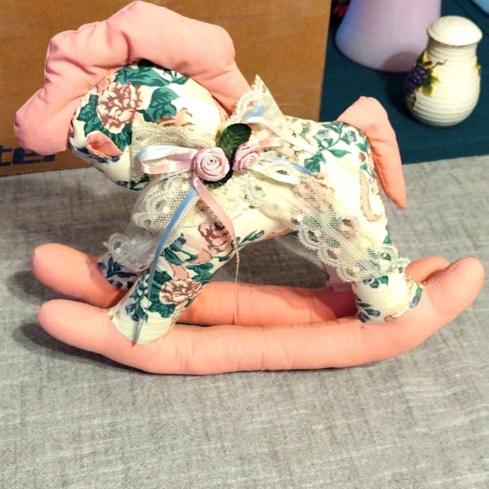 Stuffed rocking horse with lace and flowers.